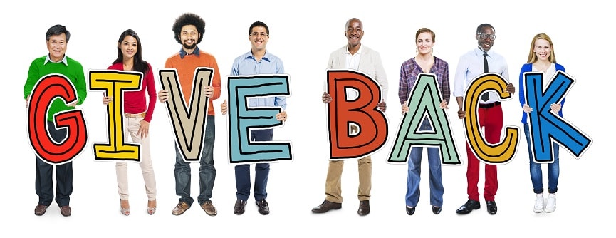 Eight people holding the letters to the word 'Give Back' and smiling