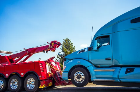 Blue commercial truck being towed